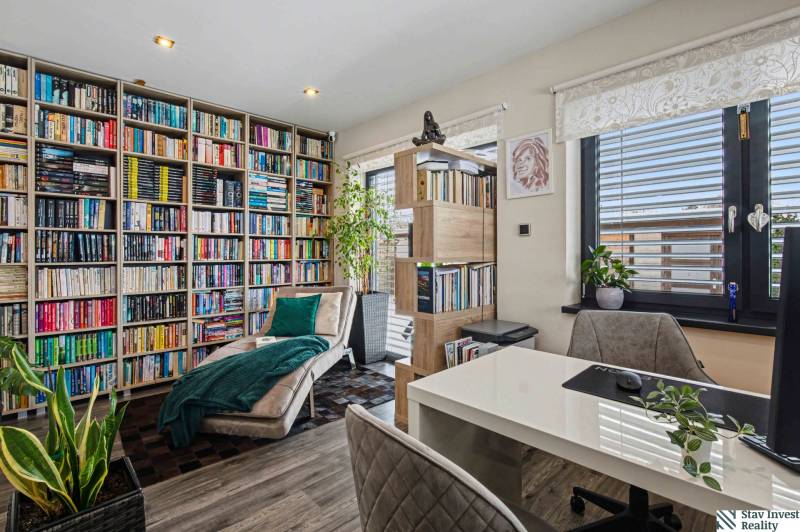 Ideálny dom pre rodinu, Blatné, okr. Senec - Domáca knižnica s pohodlným kreslom a stolíkom, obklopená rastlinami a knihami.