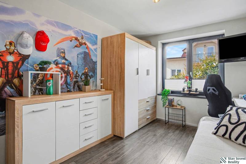 Ideálny dom pre rodinu, Blatné, okr. Senec - Detská izba v Rodinnom dome s podlahou s dreveným dekorom a komiksovou tapetou.