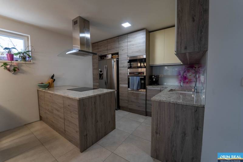 ATRAKTÍVNY 2 IZBOVÝ BYT S VLASTNOU ZÁHRADKOU a 3 parkovacími miestami - Kuchyňa v 2-izbovom byte s kútom, skriňami a spotrebičmi, podlaha s dreveným dekorom.