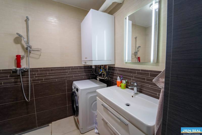 ATRAKTÍVNY 2 IZBOVÝ BYT S VLASTNOU ZÁHRADKOU a 3 parkovacími miestami - Kúpeľňa v 2-izbovom byte s práčkou, sprchovacím kútom a umývadlom so skrinkou.