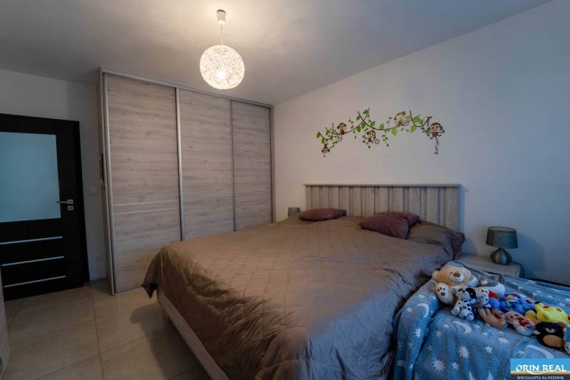 ATRAKTÍVNY 2 IZBOVÝ BYT S VLASTNOU ZÁHRADKOU a 3 parkovacími miestami - Spálňa v 2-izbovom byte s veľkou posteľou, vstavanou skriňou a detskými dekoráciami.