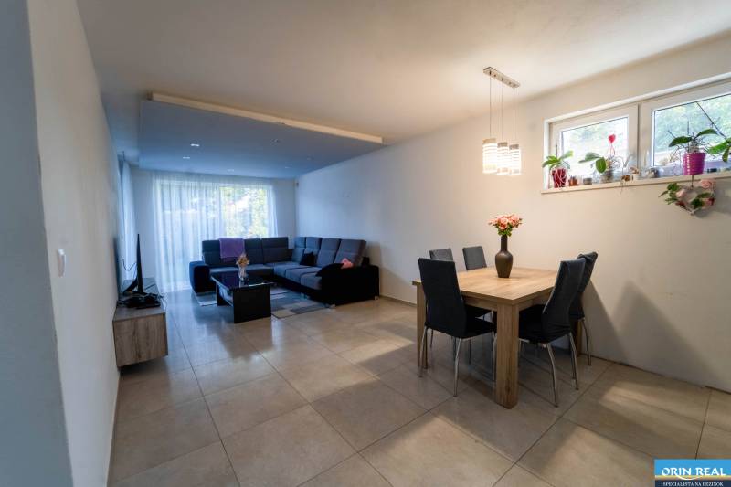 ATRAKTÍVNY 2 IZBOVÝ BYT S VLASTNOU ZÁHRADKOU a 3 parkovacími miestami - Obývacia izba v 2-izbovom byte s jedálenským stolom a rohovou sedačkou.