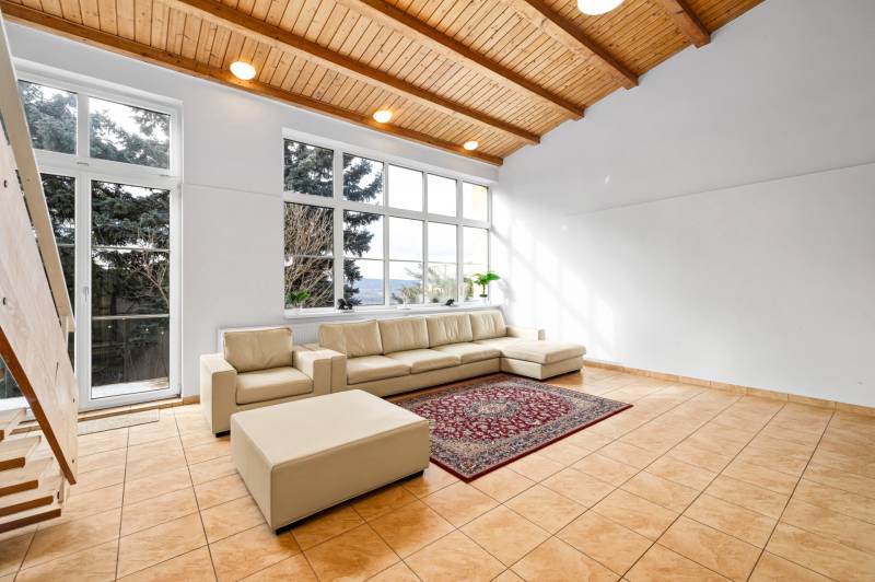 – EXKLUZÍVNE – NA PRENAJOM – DOM – MEDZIERKA – STARÉ MESTO - Obývačka v rodinnom dome s krémovou sedačkou, veľkými oknami a keramickou dlažbou.