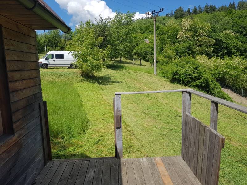 Na predaj záhradná chatka - Drevená terasa chaty v Žarnovici na ulici Na Gremenici, s výhľadom na zelený dvor.