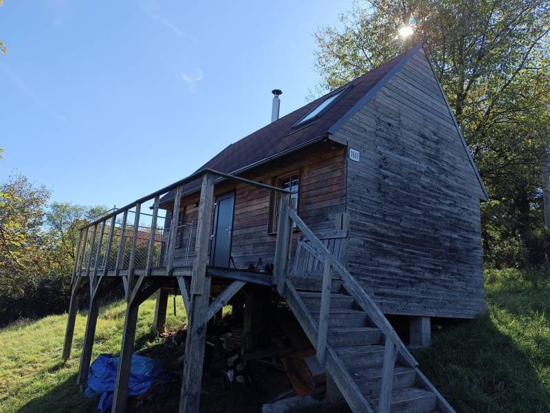 Na predaj záhradná chatka - Drevená chata na ulici Na Gremenici, Žarnovica, obklopená zeleňou a modrou oblohou.