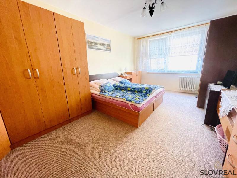 Na predaj veľký 3-izbový byt s lodžiou v Detve - Novosady - Spálňa v 3-izbovom byte so skriňou, manželskou posteľou a kobercom.