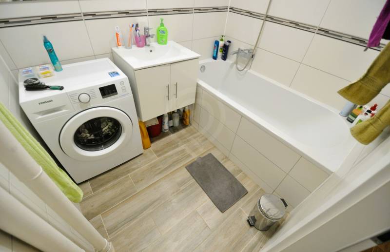 2 - izbový byt - 54 m², Hamuliakovo, internet v cene ! - Kúpeľňa v 2-izbovom byte s vaňou, práčkou a podlahou s dreveným dekorom.