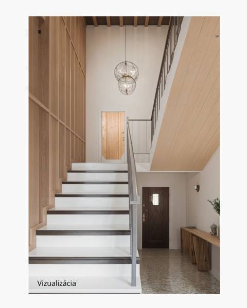 Dvojgeneračný rodinný dom s potenciálom | 2 bytové jednotky, TV - Schodisko v rodinnom dome s dreveným obkladom, svietidlá a dekoratívny stôl na chodbe.