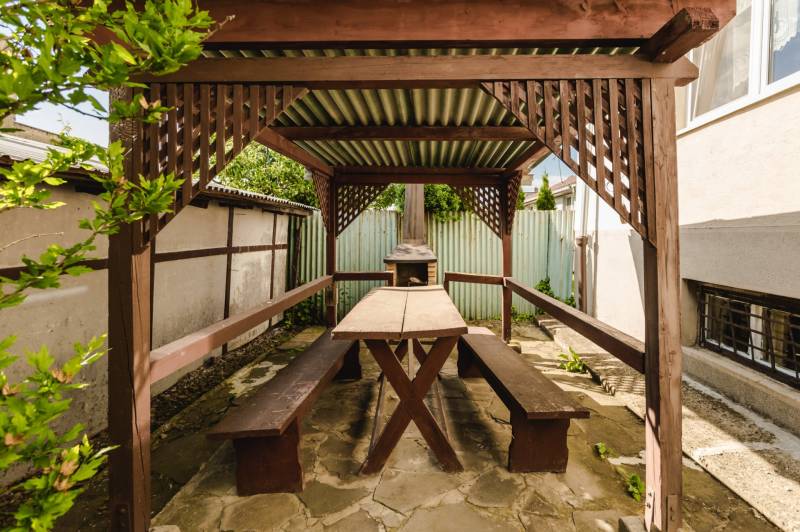 Dvojgeneračný rodinný dom s potenciálom | 2 bytové jednotky, TV - Drevený prístrešok s posedením v záhrade rodinného domu na SNP ulici v Trebišove.