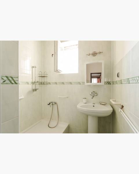 Dvojgeneračný rodinný dom s potenciálom | 2 bytové jednotky, TV - Kúpeľňa v rodinnom dome s vaňou, umývadlom a zrkadlom, obkladaná svetlými dlaždicami.