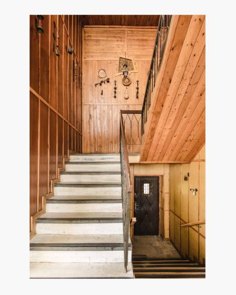 Dvojgeneračný rodinný dom s potenciálom | 2 bytové jednotky, TV - Schodisko v rodinnom dome s drevenými dekoráciami a dreveným obložením na stenách.