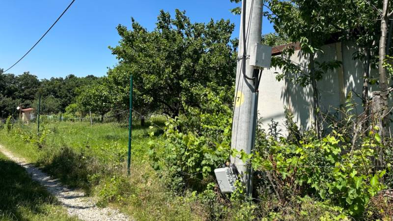 NA PREDAJ stavebný pozemok pod Zoborom ‼️znizena cena - Na obrázku je úzka cesta s elektrickým stĺpom obklopená zeleňou a plotom.