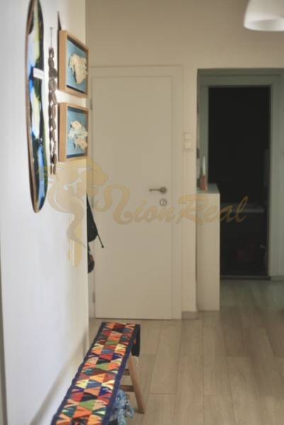 Veľký 2-izb. byt v tehlovom dome, Ružová dolina, Ružinov časť Nivy - Chodba v 2-izbovom byte s umením na stenách a podlahou s dreveným dekorom.