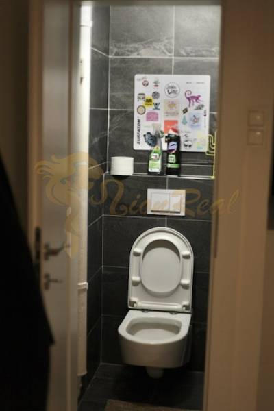 Veľký 2-izb. byt v tehlovom dome, Ružová dolina, Ružinov časť Nivy - Toaleta v 2-izbovom byte s tmavými obkladmi a bežným vybavením.