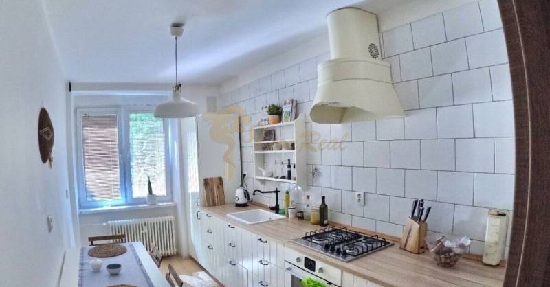 Veľký 2-izb. byt v tehlovom dome, Ružová dolina, Ružinov časť Nivy - Kuchyňa s podlahou s dreveným dekorom a bielym nábytkom v 2-izbovom byte.