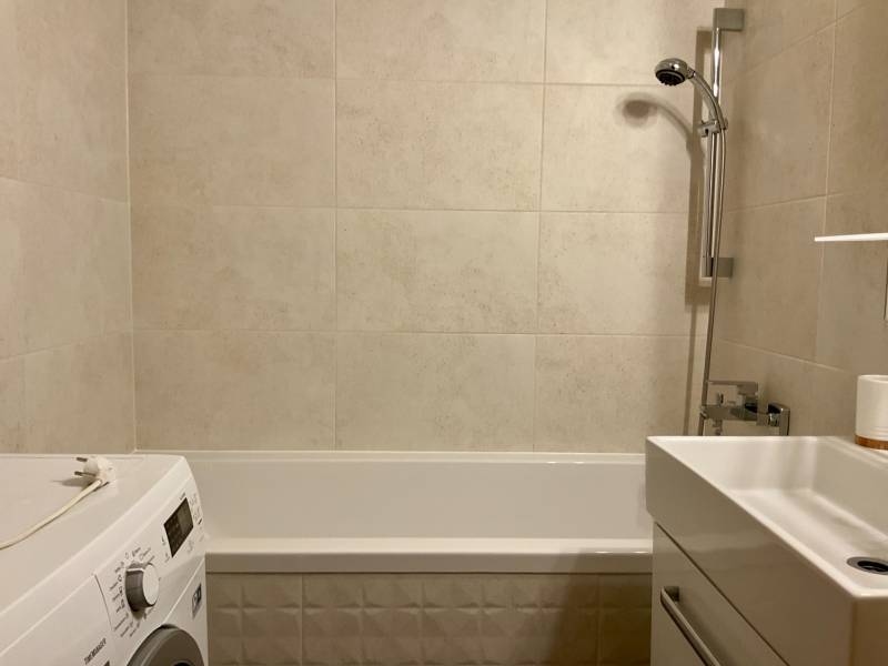 I Prenájom moderne zariadeného 3-izbového bytu v Petržalke. - Kúpeľňa v 3-izbovom byte s vaňou, umývadlom a práčkou, svetlé obklady.