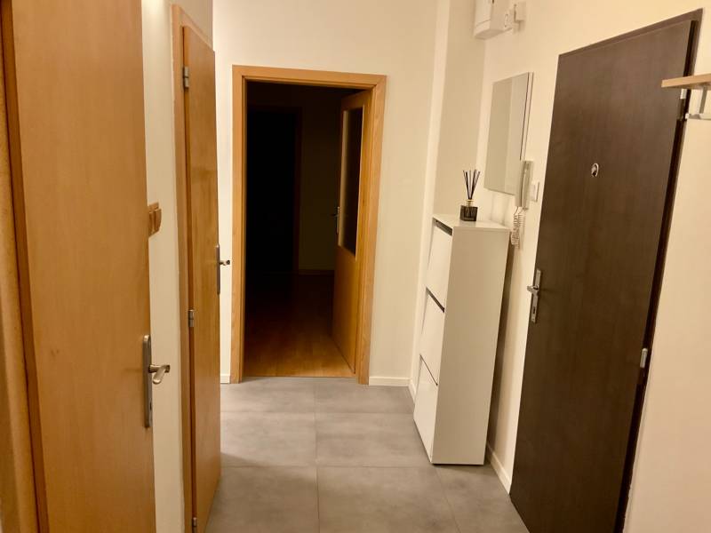 I Prenájom moderne zariadeného 3-izbového bytu v Petržalke. - Vstupná chodba v 3-izbovom byte s dlažbou a bielou skriňou.