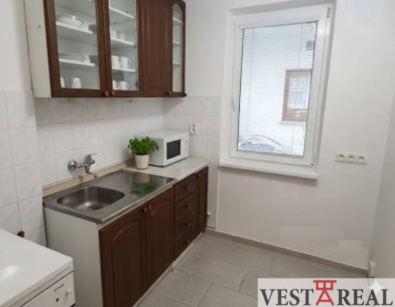 Na predaj: 2-izbový byt v centre mesta Galanta – časť Nová Doba - Kuchyňa 2-izbového bytu s tmavým nábytkom, spotrebičmi a svetlou dlažbou.