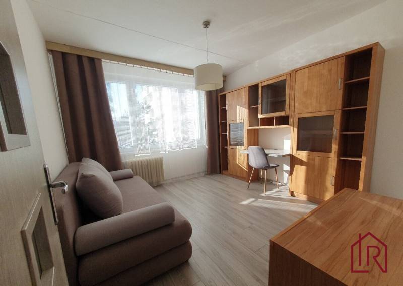 KH-1052, 3 izbový byt, Košice – Staré Mesto, širšie centrum, Kuzmányho - Obývacia izba v 3-izbovom byte so sedačkou, pracovným stolom a podlahou s dreveným dekorom.