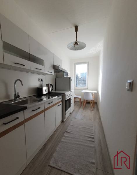 KH-1052, 3 izbový byt, Košice – Staré Mesto, širšie centrum, Kuzmányho - Kuchyňa v 3-izbovom byte s podlahou s dreveným dekorom a bielym nábytkom.