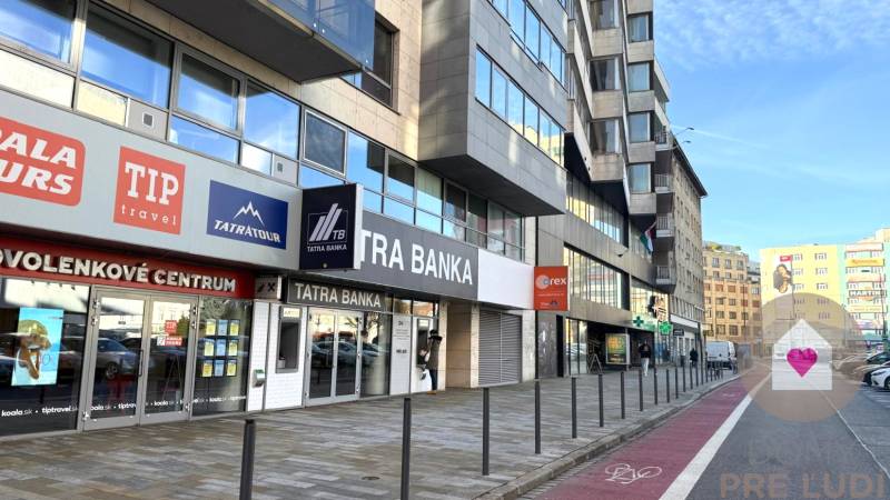 Krásny slnečný kancelársky priestor, BA Staré Mesto, Dunajská - Budova na Dunajskej ulici v Bratislave - Starom Meste s reklamami a vstupmi do kancelárií.