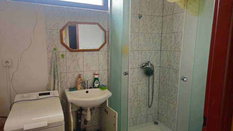 Predaj 4 izbový rodinný dom Šulekovo  - Kúpeľňa v rodinnom dome so sprchovacím kútom, umývadlom a práčkou.