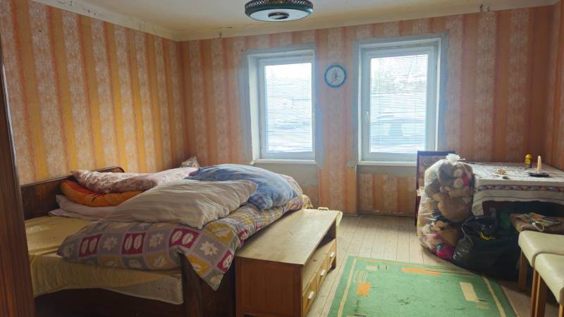 Predaj 4 izbový rodinný dom Šulekovo  - Izba v rodinnom dome s posteľou, stolom a hračkami, s dreveným dekorom podlahy.