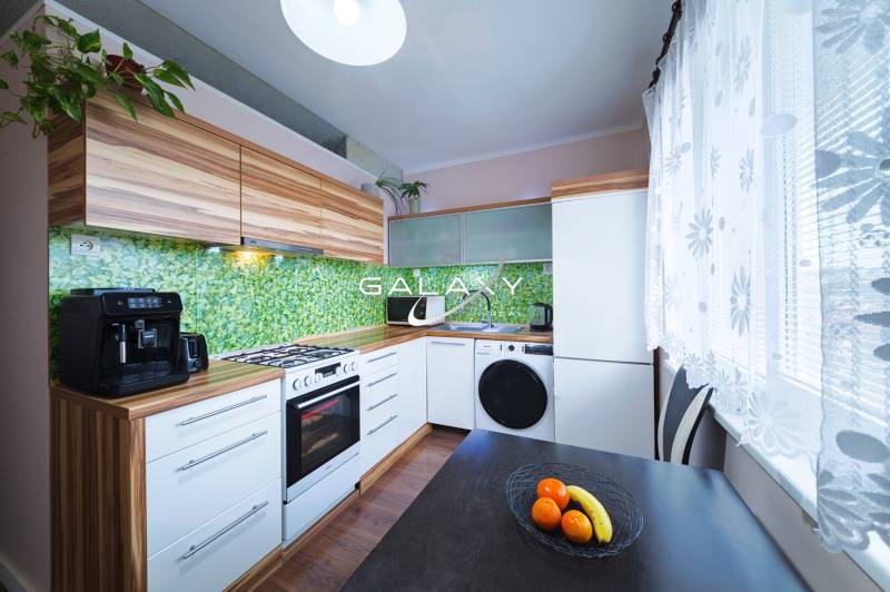 Kompletne zrekonštruovaný 3-izbový byt s balkónom – Rimavská Sobota - Kuchyňa v 3-izbovom byte s dreveným dekorom a zariadením.