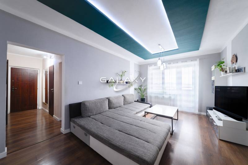 Kompletne zrekonštruovaný 3-izbový byt s balkónom – Rimavská Sobota - Svetlá obývačka v 3-izbovom byte s podlahou s dreveným dekorom a pohodlným sedením.