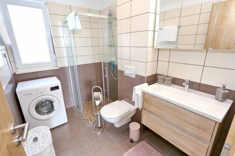 CHORVÁTSKO - VÝBORNÁ PONUKA! - 3-izbový apartmán - SUKOŠAN, Zadar - Kúpeľňa v 3-izbovom byte s práčkou, sprchovým kútom a toaletou, podlaha s dreveným dekorom.