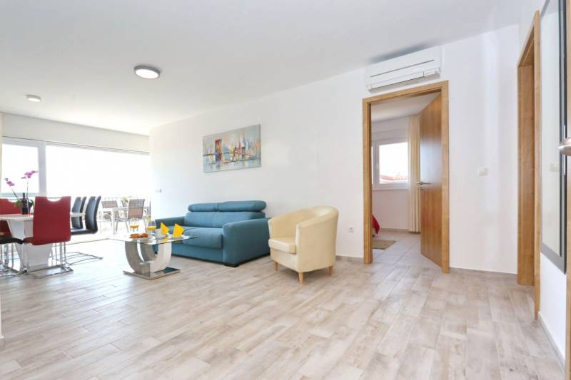 CHORVÁTSKO - VÝBORNÁ PONUKA! - 3-izbový apartmán - SUKOŠAN, Zadar - Svetlý interiér 3-izbového bytu s podlahou s dreveným dekorom a pohodlným sedením.