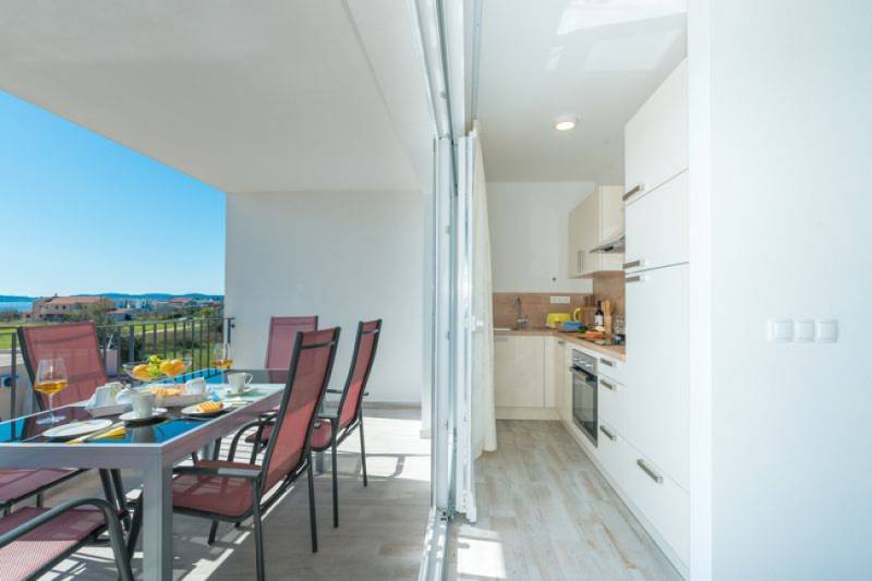 CHORVÁTSKO - VÝBORNÁ PONUKA! - 3-izbový apartmán - SUKOŠAN, Zadar - Jasne presvetlená terasa s jedálenským stolom a výhľadom na SUKOŠAN. K tomu kuchyňa.