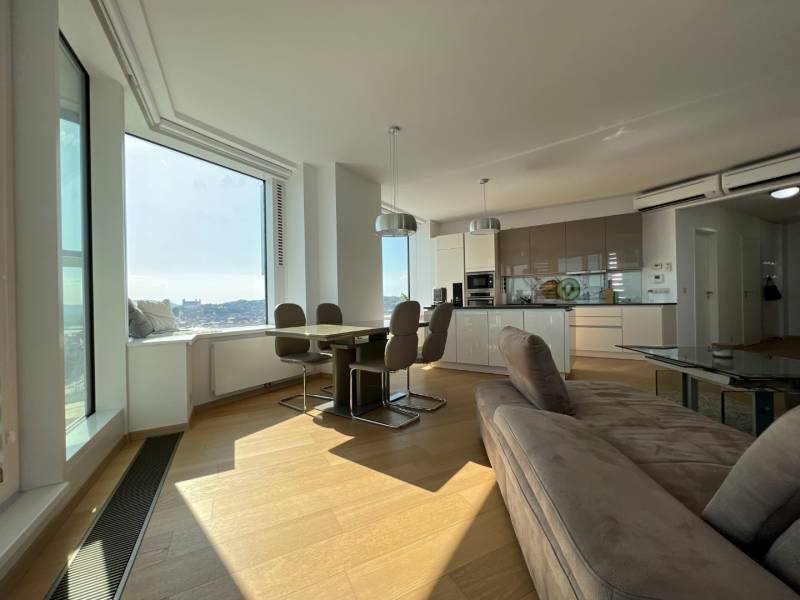 NUERA︱PANORAMA CITY- Veľký 3-izbový byt s výhľadom na hrad - Obývacia izba v 3-izbovom byte s kuchyňou a podlahou s dreveným dekorom.