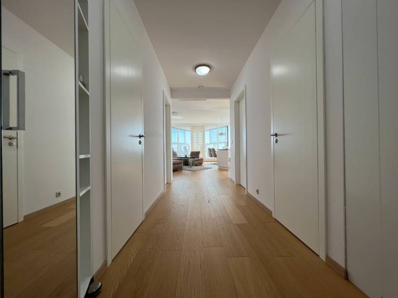 NUERA︱PANORAMA CITY- Veľký 3-izbový byt s výhľadom na hrad - Chodba 3-izbového bytu s podlahou s dreveným dekorom a bielymi dverami.