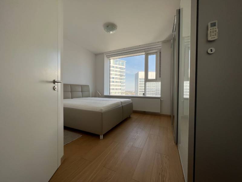 NUERA︱PANORAMA CITY- Veľký 3-izbový byt s výhľadom na hrad - Svetlá spálňa s posteľou a podlahou s dreveným dekorom v 3-izbovom byte.