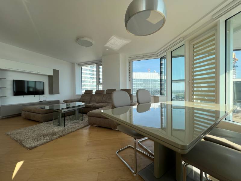 NUERA︱PANORAMA CITY- Veľký 3-izbový byt s výhľadom na hrad - Obývačka v 3-izbovom byte s podlahou s dreveným dekorom, veľkým oknom a sedačkou.