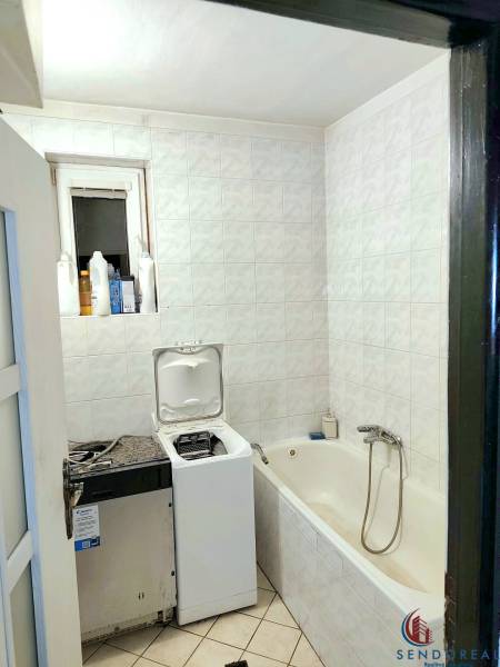 5.izb RD Čereňany pozemok 1028m - Kúpeľňa v Rodinnom dome s vaňou, práčkou a bielymi obkladačkami na stenách.