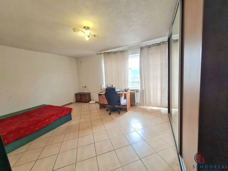 5.izb RD Čereňany pozemok 1028m - Izba v rodinnom dome s kachličkovou podlahou, posteľou, stolom a skriňou.