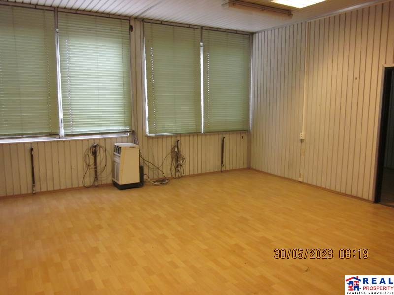 KOŠICE, NAD JAZEROM - Napájadlá: Malý SKLAD 13,2 m2 alebo kancelária - Miestnosť s podlahou s dreveným dekorom, biele steny, žalúzie a elektrické ohrievače v Skladoch a halách.