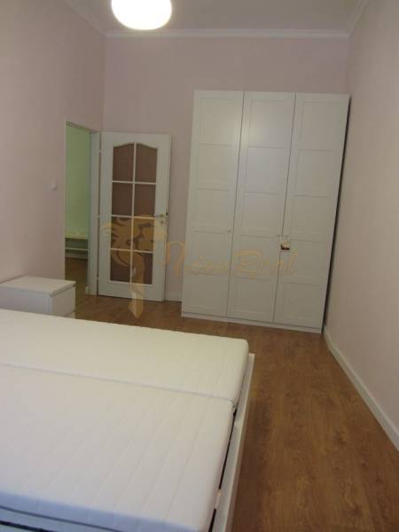 4-izb.byt v centre mesta, Obchodná ul., BA I - Staré Mesto, 2 x balkón - Spálňa s bielou skriňou, posteľou a podlahou s dreveným dekorom v 4-izbovom byte.