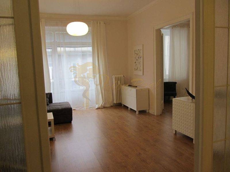 4-izb.byt v centre mesta, Obchodná ul., BA I - Staré Mesto, 2 x balkón - Obývacia izba v 4-izbovom byte s podlahou s dreveným dekorom a svetlým zariadením.