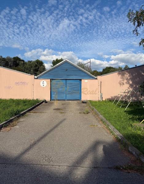 Garáž ul. Eisnerova, Devínska Nová Ves - Garáže na Eisnerovej ulici v Bratislave - Devínskej Novej Vsi, s modrou bránou a graffiti.