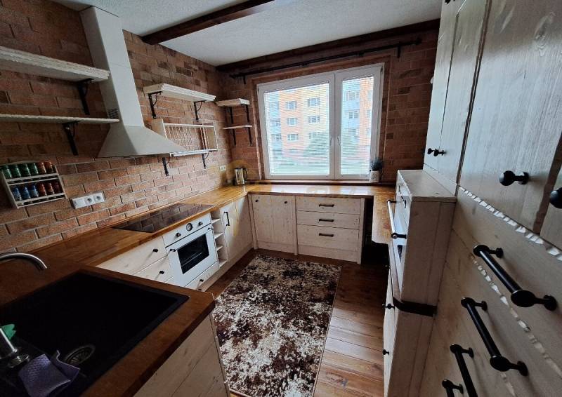 3-izb. byt, Haanova, BA V - Petržalka, kompletná rekonštrukcia - Kuchyňa 3-izbového bytu s tehlovým obkladom, masívnymi policami na ulici Haanova.