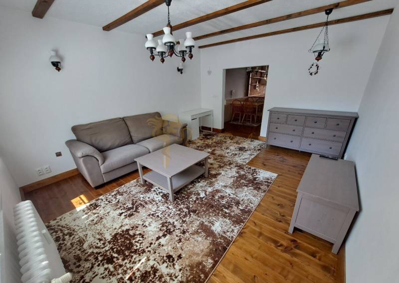 3-izb. byt, Haanova, BA V - Petržalka, kompletná rekonštrukcia - Obývačka na ulici Haanova, 3-izbový byt s drevenou podlahou, sedačkou a konferenčným stolíkom.