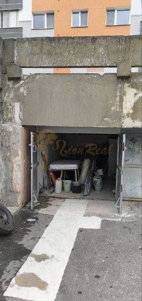 Garáž, Dudvažská ul., Podunajské Biskupice - Garáže na Dudvážskej ulici v Bratislave - Podunajských Biskupiciach s otvorenou bránou a rôznymi predmetmi.