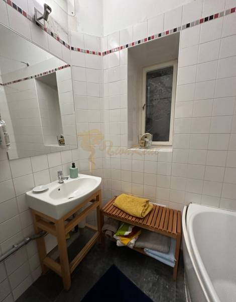 3,5 izb. byt v priamo centre Bratislavy na pešej zóne - Kúpeľňa 4-izbového bytu s vaňou, zrkadlom a drevenou poličkou.