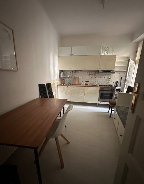 3,5 izb. byt v priamo centre Bratislavy na pešej zóne - Kuchyňa v 4-izbovom byte s jedálenským stolom a stoličkami.