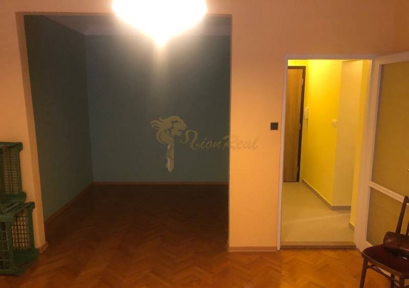 1-izb. byt na ul. Račianska, Nové Mesto s lodžiou - Interiér 1-izbového bytu s podlahou s dreveným dekorom a svetlým osvetlením.