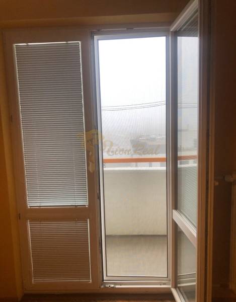 1-izb. byt na ul. Račianska, Nové Mesto s lodžiou - Dvere a okno so žalúziami v 1-izbovom byte, výhľad na balkón.