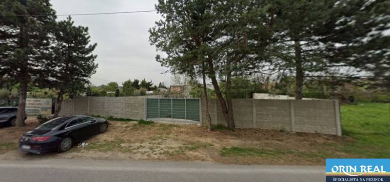 Na predaj pozemok na pohrebnicku činnosť Bernolákovo - Pozemky - komerčné na Dukelskej v Bernolákove s betónovým plotom a príjazdovou cestou.